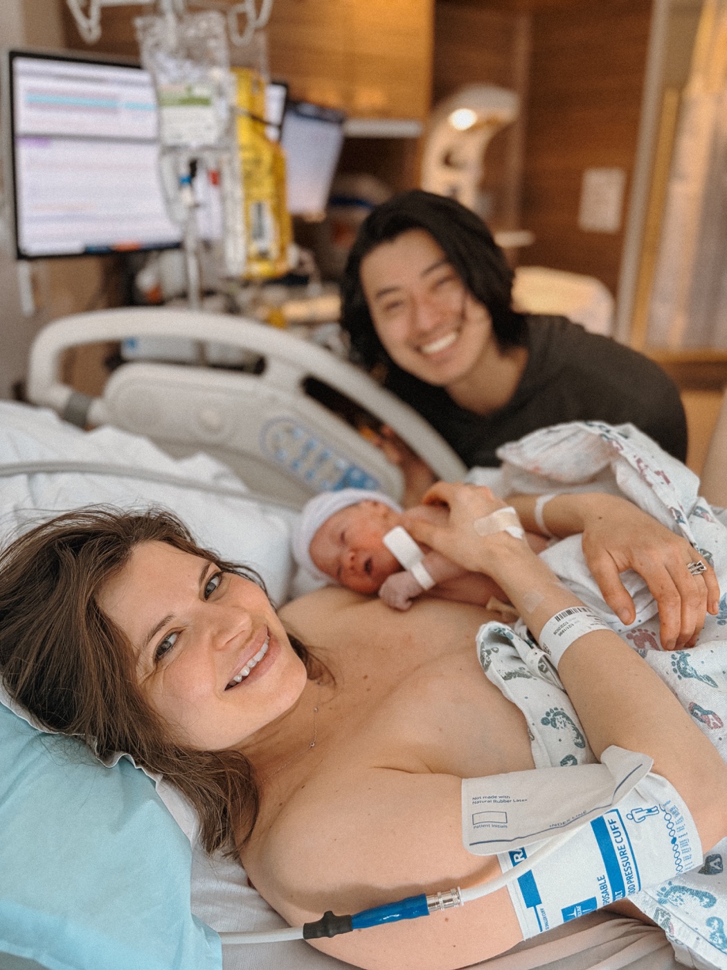 Mother smiling with her newborn resting on her chest after birth